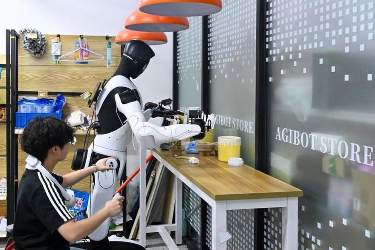 A worker trains an Agibot humanoid robot at a store in Shanghai.