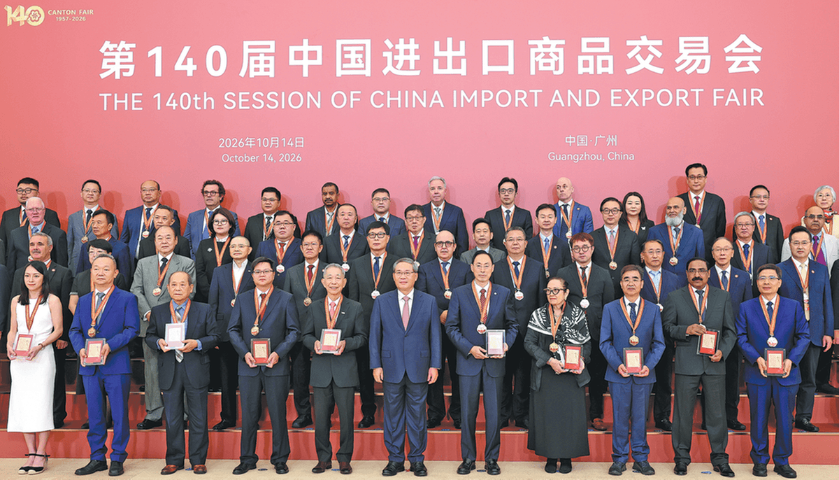 第140届中国进出口商品交易会颁奖合影现场,多位获奖代表与嘉宾身着正装,佩戴奖章在舞台上合影。