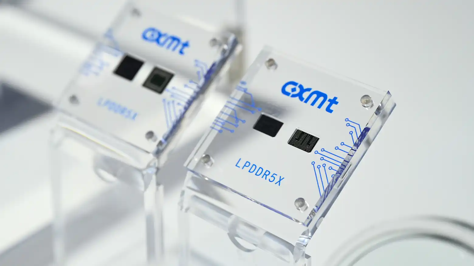 两块印有CXMT标识的LPDDR5X内存芯片展示模型,置于透明亚克力底座上。
