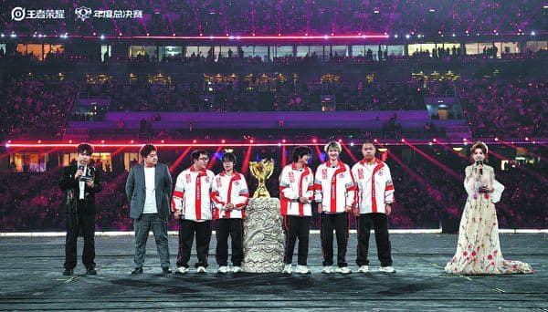 A champion team poses with the trophy at the Honor of Kings Pro League grand finals.