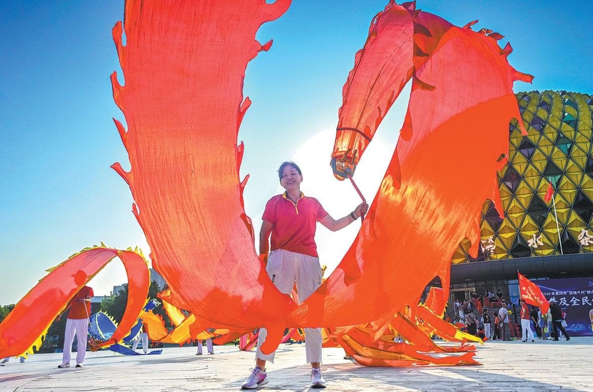 A fitness enthusiast performs a ribbon dragon dance on a square in Xishui, Hubei province.
