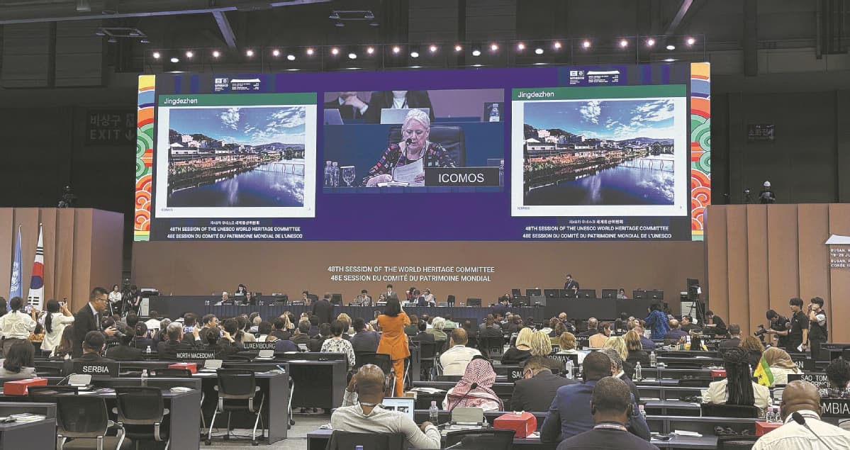 A UNESCO World Heritage Committee session with Jingdezhen's nomination shown on the screens.