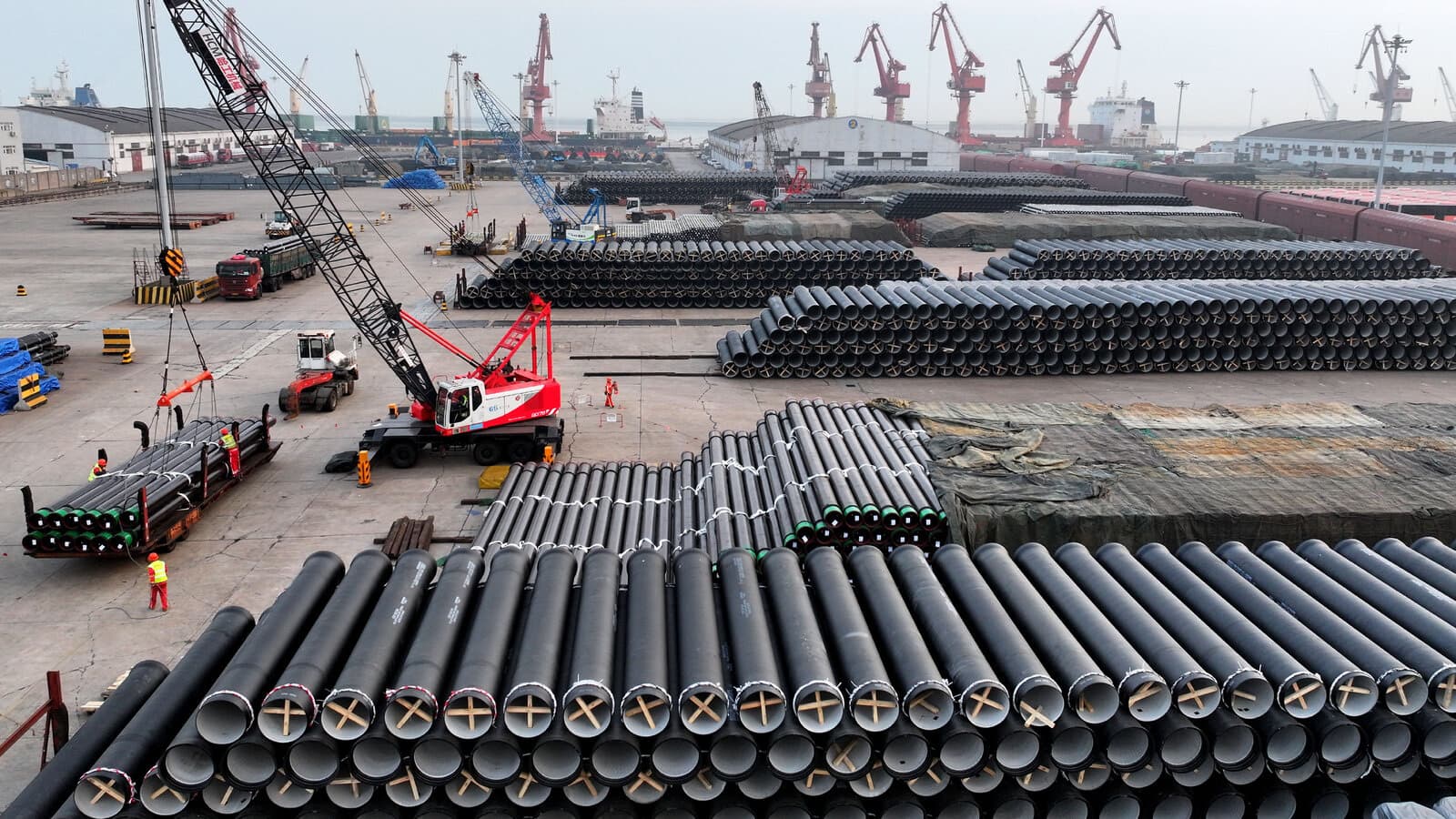 Rows of steel pipes await shipment at a port storage yard
