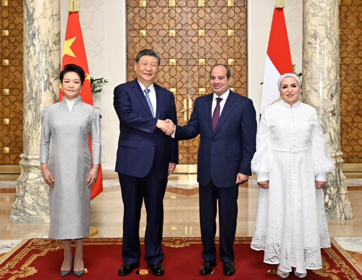 Inside the presidential palace in Cairo, President Xi Jinping and his wife, Peng Liyuan, pose with Egyptian President Abdel Fattah El-Sisi and his wife, with the flags of China and Egypt behind them.