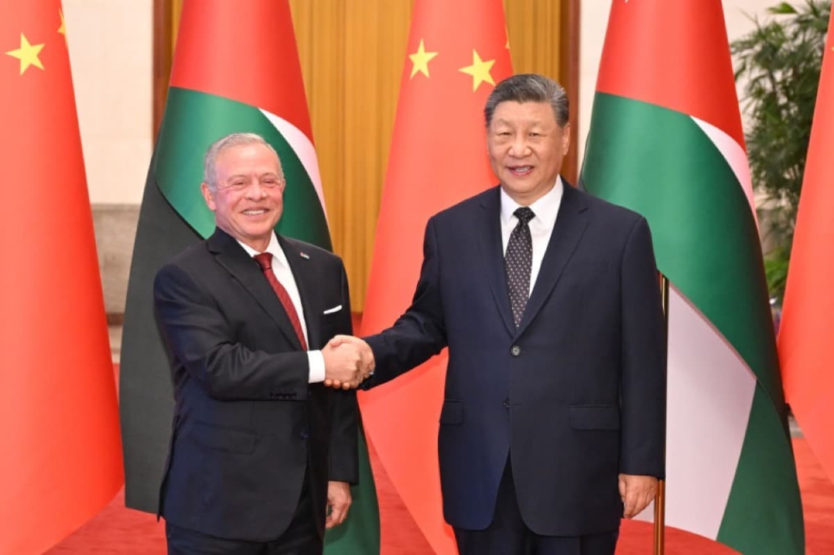 President Xi Jinping shakes hands with King Abdullah II of Jordan inside the Great Hall of the People in Beijing, with the flags of China and Jordan behind them.