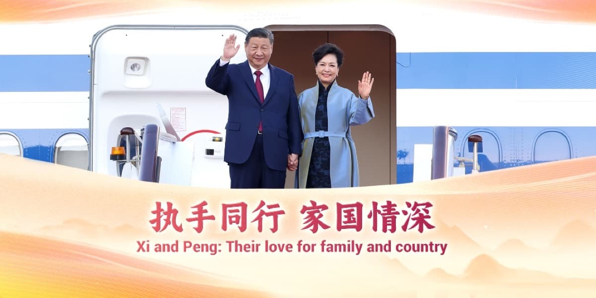 A Qixi Festival poster showing President Xi Jinping and his wife, Peng Liyuan, waving beside an aircraft staircase, captioned their love for family and country.