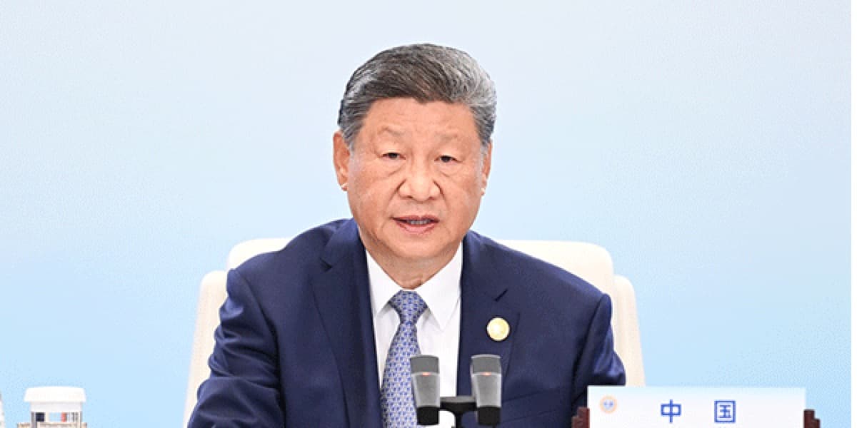 国家主席习近平在一场多边会议上讲话,面前摆放着写有中国字样的座位牌与话筒。