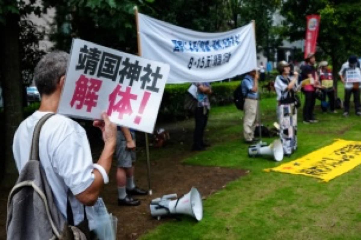 Protesters near the Yasukuni Shrine in Tokyo, with a banner reading dismantle Yasukuni Shrine.
