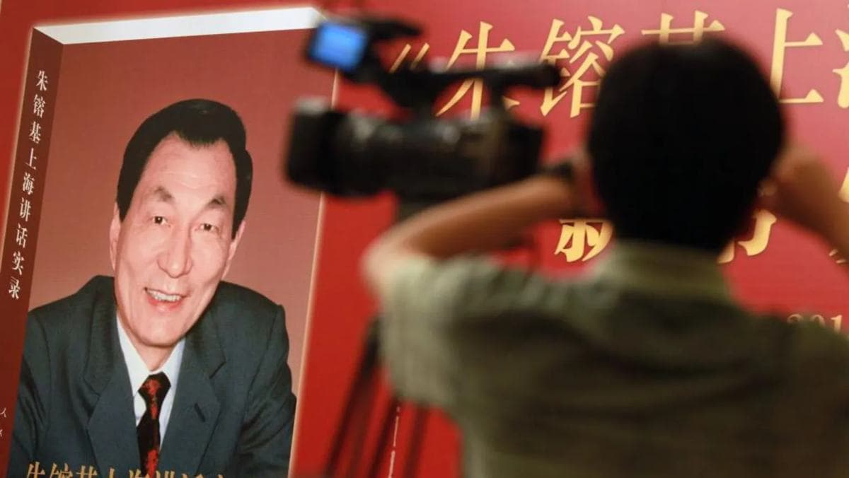 A cameraman films a book of Zhu Rongji's speeches, its cover showing a photograph of Zhu.
